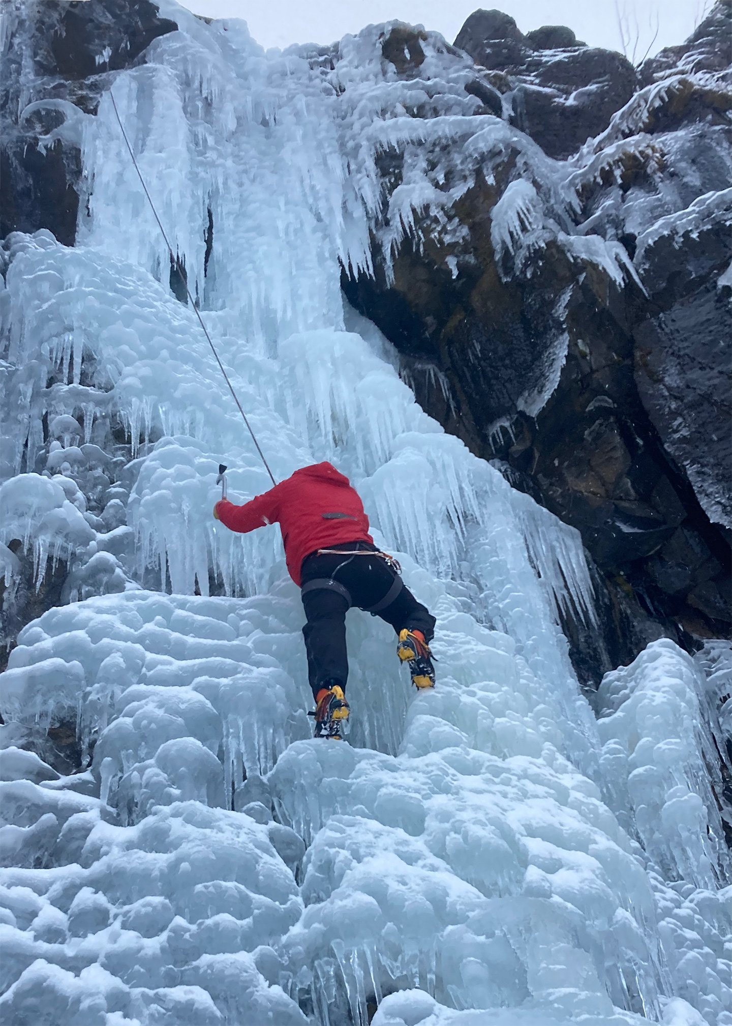 Climber ascending one of many ice waterfalls in Seyðisfjörður.