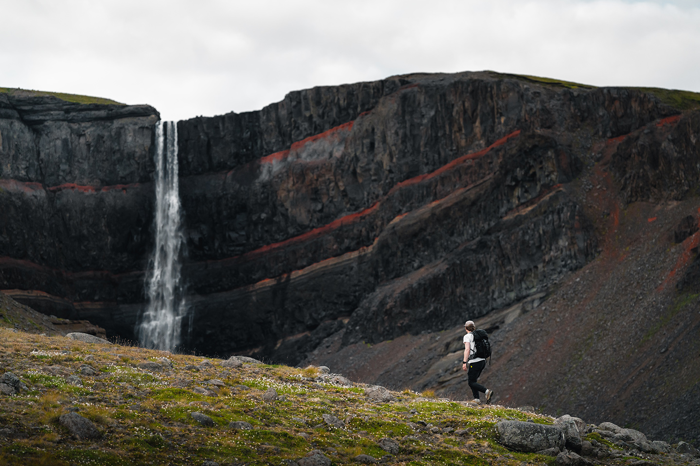 A man hiking near Hengifoss waterfall