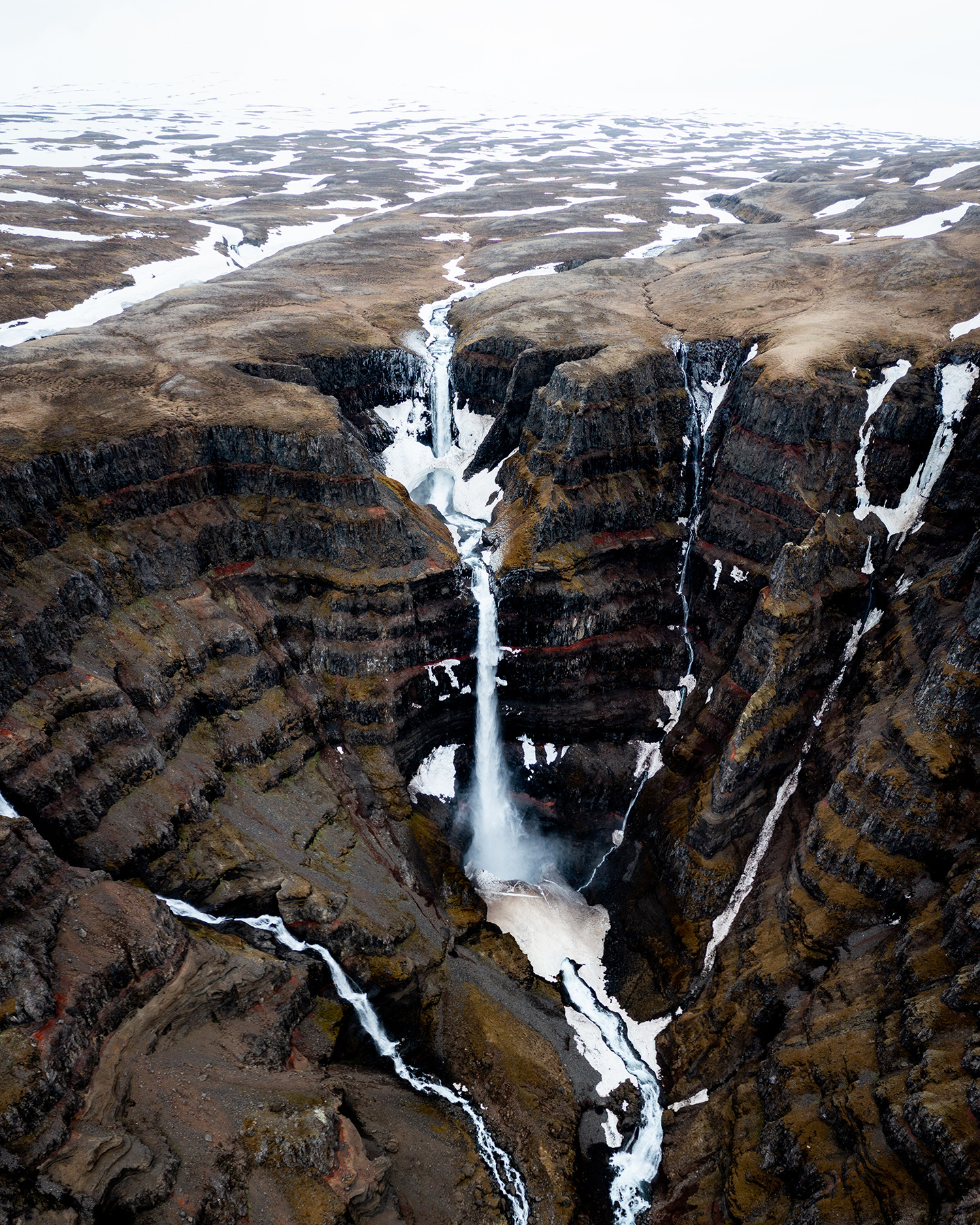 Strútsfoss ist der Cousin des Hengifoss Wasserfalls mit Basaltlava und roten und braunen Sedimenten
